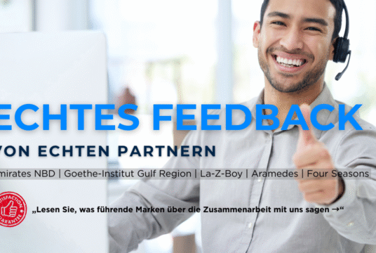 „Lächelnder junger Mann mit Headset zeigt Daumen hoch – Text: Echtes Feedback von echten Partnern. Emirates NBD, Goethe-Institut Golfregion, La-Z-Boy, Aramedes, Four Seasons. Call-to-Action: Lesen Sie, was führende Marken über die Zusammenarbeit mit uns sagen.“